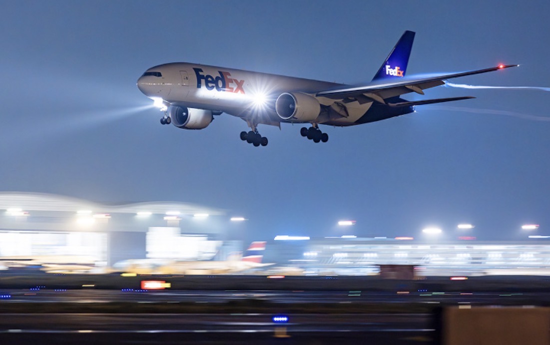 FedEx Boeing 777F cargo aircraft landing on a runway at night